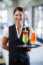 Portrait of smiling waitress serving cocktail Royalty Free Stock Photo