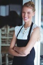 Portrait of smiling waitress standing with arms crossed Royalty Free Stock Photo