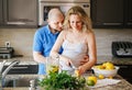 Portrait of smiling white Caucasian couple two people pregnant woman with husband cooking food Royalty Free Stock Photo