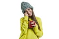 Portrait of smiling winter young woman in knitted hat, yellow sweater with cup of hot drink, isolated on white Royalty Free Stock Photo