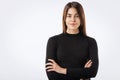 Close-up of confident young woman with folded arms against white background Royalty Free Stock Photo