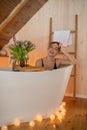 Portrait of smiling woman in black underwear relaxing and spending weekend at home. Taking bath with glass of wine on Royalty Free Stock Photo