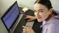 Portrait of smiling woman in casual clothing working on laptop at home office at home based business and looking at camera. Close- Royalty Free Stock Photo