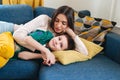 Portrait of smiling woman and child lying on sofa. Cute family is happy and looking perfect Royalty Free Stock Photo