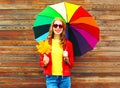 Portrait smiling woman with colorful umbrella in autumn with maple leaves Royalty Free Stock Photo