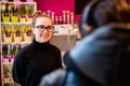 Portrait of smiling woman, flower shop owner, standing at her work place talking with customer Royalty Free Stock Photo