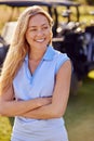 Portrait Of Smiling Woman Golfer Standing By Buggy On Golf Course Royalty Free Stock Photo