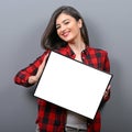 Portrait of smiling woman holding blank sign board.Studio portrait of young woman with sign card against gray background Royalty Free Stock Photo