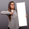 Portrait of smiling woman holding blank sign board.Studio portrait of young woman with sign card against gray background Royalty Free Stock Photo