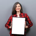 Portrait of smiling woman holding blank sign board.Studio portrait of young woman with sign card against gray background Royalty Free Stock Photo