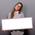 Portrait of smiling woman holding blank sign board.Studio portrait of young woman with sign card against gray background Royalty Free Stock Photo