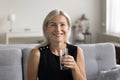 Portrait of smiling woman holding glass of fresh pure water