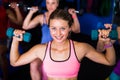 Portrait of smiling woman lifting dumbbell in gym Royalty Free Stock Photo