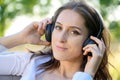 Portrait of a smiling woman listening to music on headphones outdoors in nature Royalty Free Stock Photo