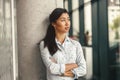 Attractive business woman standing with crossed hands and smile in office while looking at side Royalty Free Stock Photo