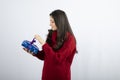 Portrait of a smiling woman opening a Christmas gift box with purple ribbon Royalty Free Stock Photo