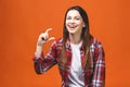 Portrait of smiling woman showing small amount of something, isolated against orange background Royalty Free Stock Photo