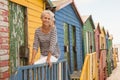 Portrait smiling woman sitting on railing of hut Royalty Free Stock Photo