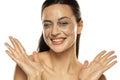 Portrait of a smiling woman with smeared makeup removing lotion on her face. in a white background