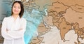 Portrait of smiling woman standing with arms crossed against world map Royalty Free Stock Photo