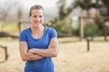 Portrait of smiling woman standing with arms crossed in during obstacle course Royalty Free Stock Photo