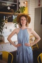 Portrait of smiling woman standing with hands on hip at coffee shop Royalty Free Stock Photo