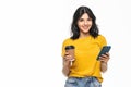 Portrait of a smiling woman using mobile phone while holding cup of coffee to go isolated over white background Royalty Free Stock Photo