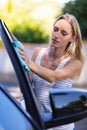 portrait smiling woman washing car windscreen at yard