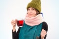 Portrait of a smiling woman in a winter hat and scarf with a cup in her hand. Viral diseases concept