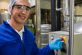 Portrait of smiling worker pressing button of machinery Royalty Free Stock Photo