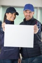 portrait smiling workers holding blank billboard