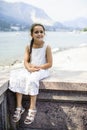 Portrait of a 7 year old girl sitting on a wall Royalty Free Stock Photo