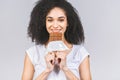 Portrait of a smiling young african american black woman eating chocolate bar isolated over grey background Royalty Free Stock Photo