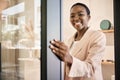 Smiling African American entrepreneur opening the door of her shop