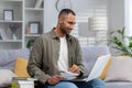 Portrait of a smiling young African American man studying at home remotely with a laptop and books. Preparing for the Royalty Free Stock Photo