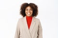 Portrait of smiling young african american saleswoman, looking professional and upbeat, standing over white background Royalty Free Stock Photo