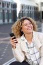 Smiling young african american woman holding mobile phone outside Royalty Free Stock Photo