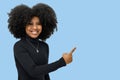 Portrait of a smiling young afro girl points to the rigth side Royalty Free Stock Photo