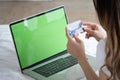 Portrait of a smiling young asian beautiful girls are shopping online with credit card in the bedroom Royalty Free Stock Photo