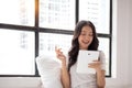 Portrait of a smiling young asian beautiful girls are shopping online with credit card in the living room Royalty Free Stock Photo