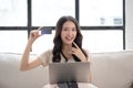 Portrait of a smiling young asian beautiful girls are shopping online with credit card in the living room Royalty Free Stock Photo