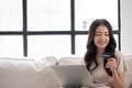 Portrait of a smiling young asian beautiful girls are shopping online with credit card in the living room Royalty Free Stock Photo