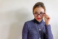 Portrait of a smiling young asian Chinese woman in eyeglasses posing while standing isolated over white background