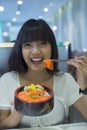 Portrait of smiling young asian woman eating japanese food Royalty Free Stock Photo