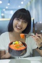 Portrait of smiling young asian woman eating japanese food Royalty Free Stock Photo