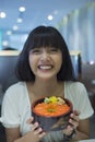 Portrait of smiling young asian woman holding japanese food Royalty Free Stock Photo