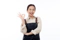 Portrait smiling young asian woman wearing apron showing ok sign with hand isolated white background. Royalty Free Stock Photo