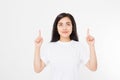 Portrait of smiling young asian woman wearing summer t shirt pointing at copy space by finger isolated on white blank background Royalty Free Stock Photo