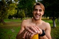 Portrait smiling young attractive male athlete resting on pole after outdoor workout smartwatch for tracking activities Royalty Free Stock Photo