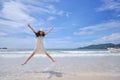 Portrait of smiling young beautiful woman jumping on the beach Royalty Free Stock Photo